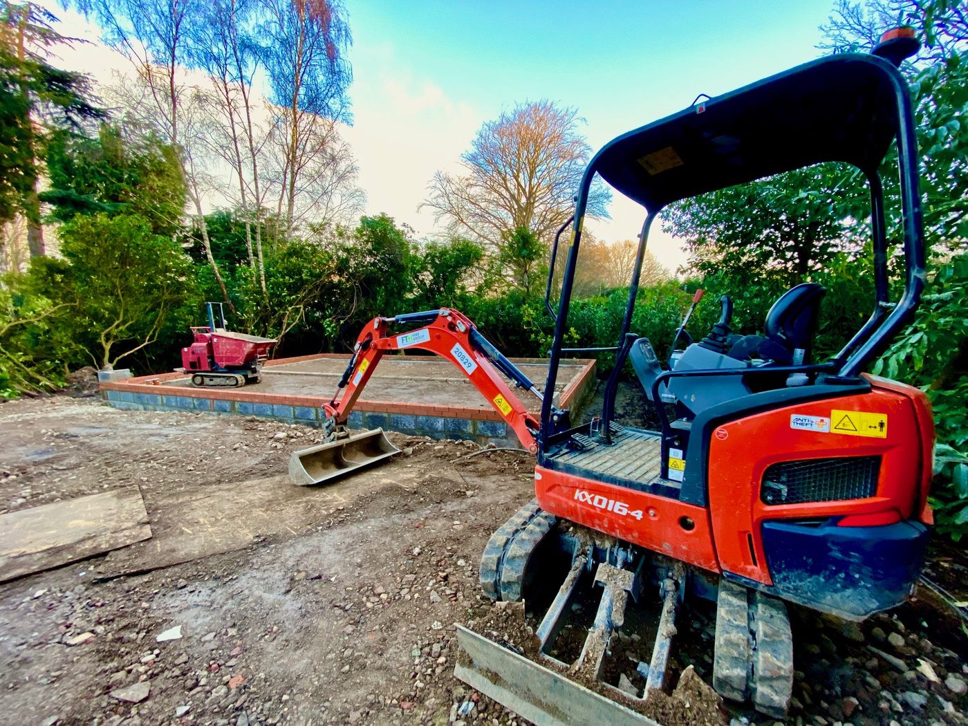 Mini digger carrying out groundworks for a new extension