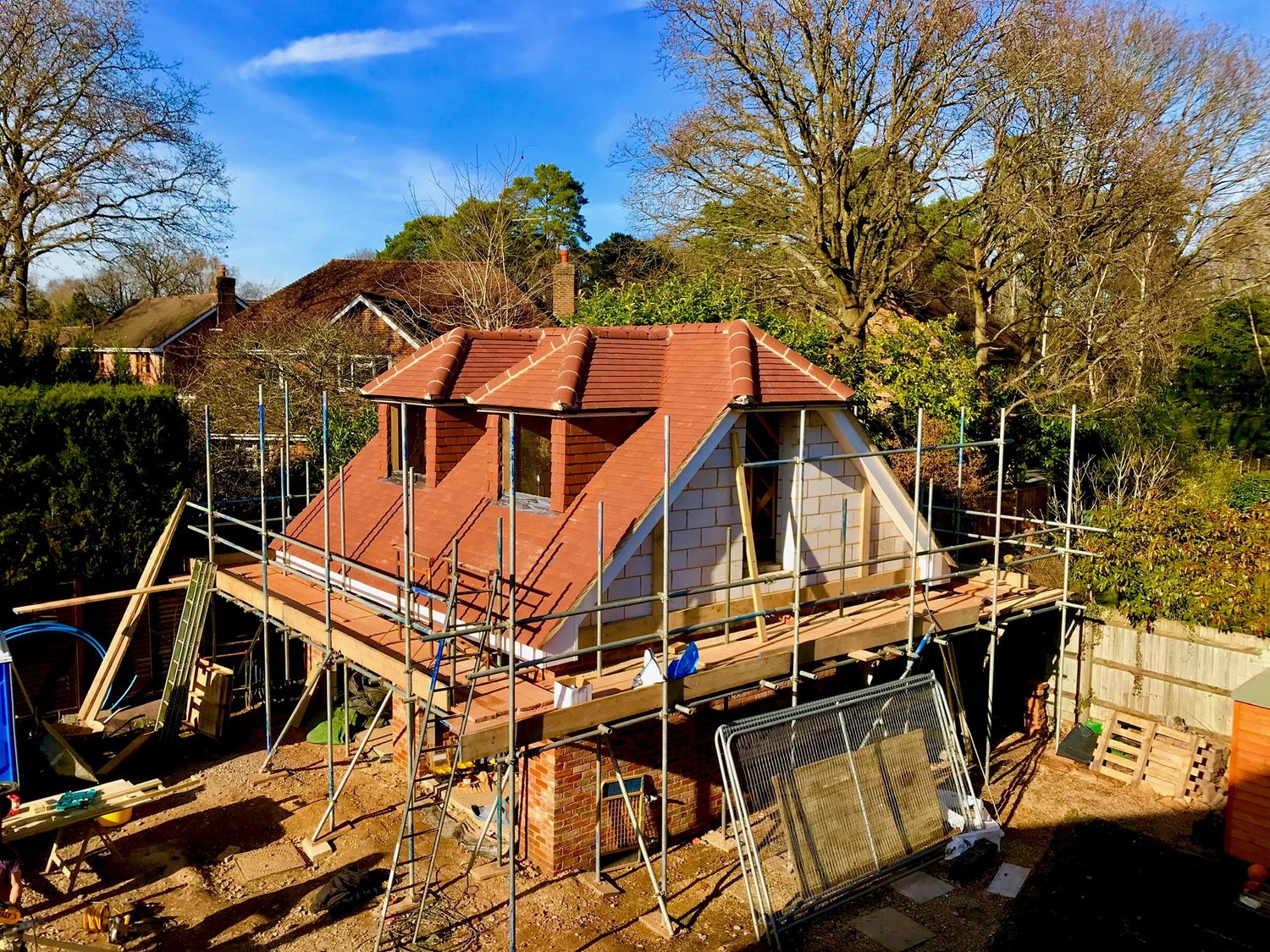 Brick extension and new dormer under construction with scaffolding
