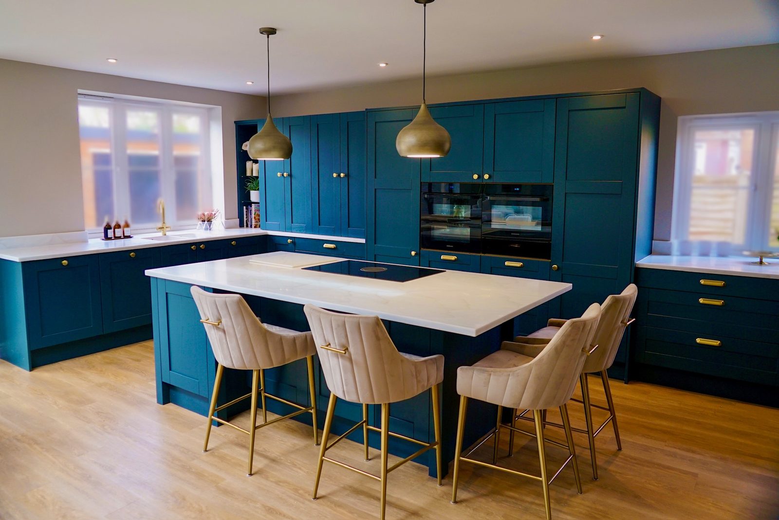 Deep blue shaker kitchen with a large island and brass pendant lighting