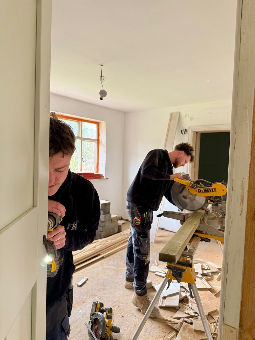 Joiners fitting second fix timber in a renovated room