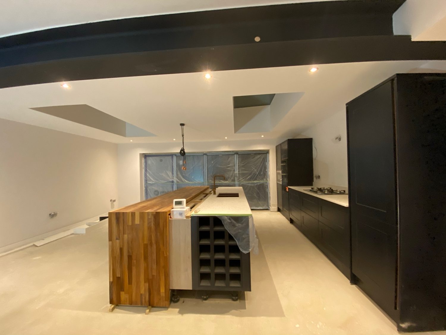 Dark handleless kitchen with a timber-fronted island