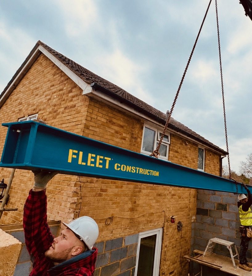 Steel beam being craned into a house during structural works