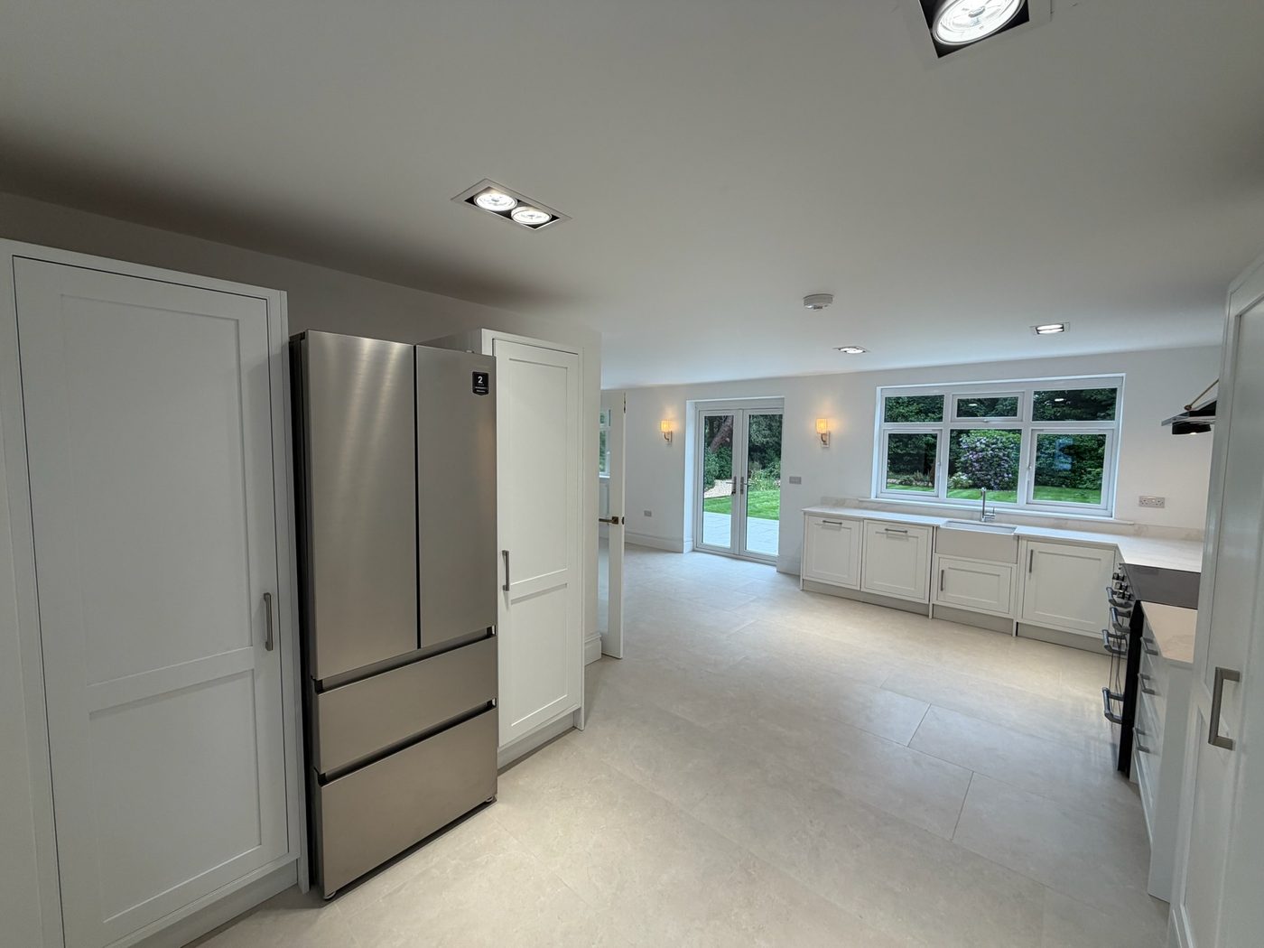 Kitchen with tall larder units and an American style fridge freezer
