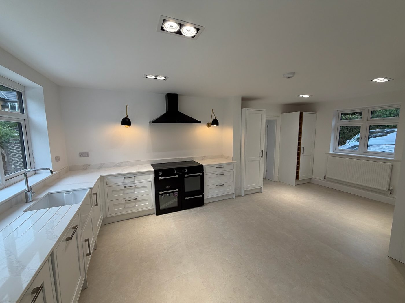 White kitchen with quartz worktops and a black range cooker