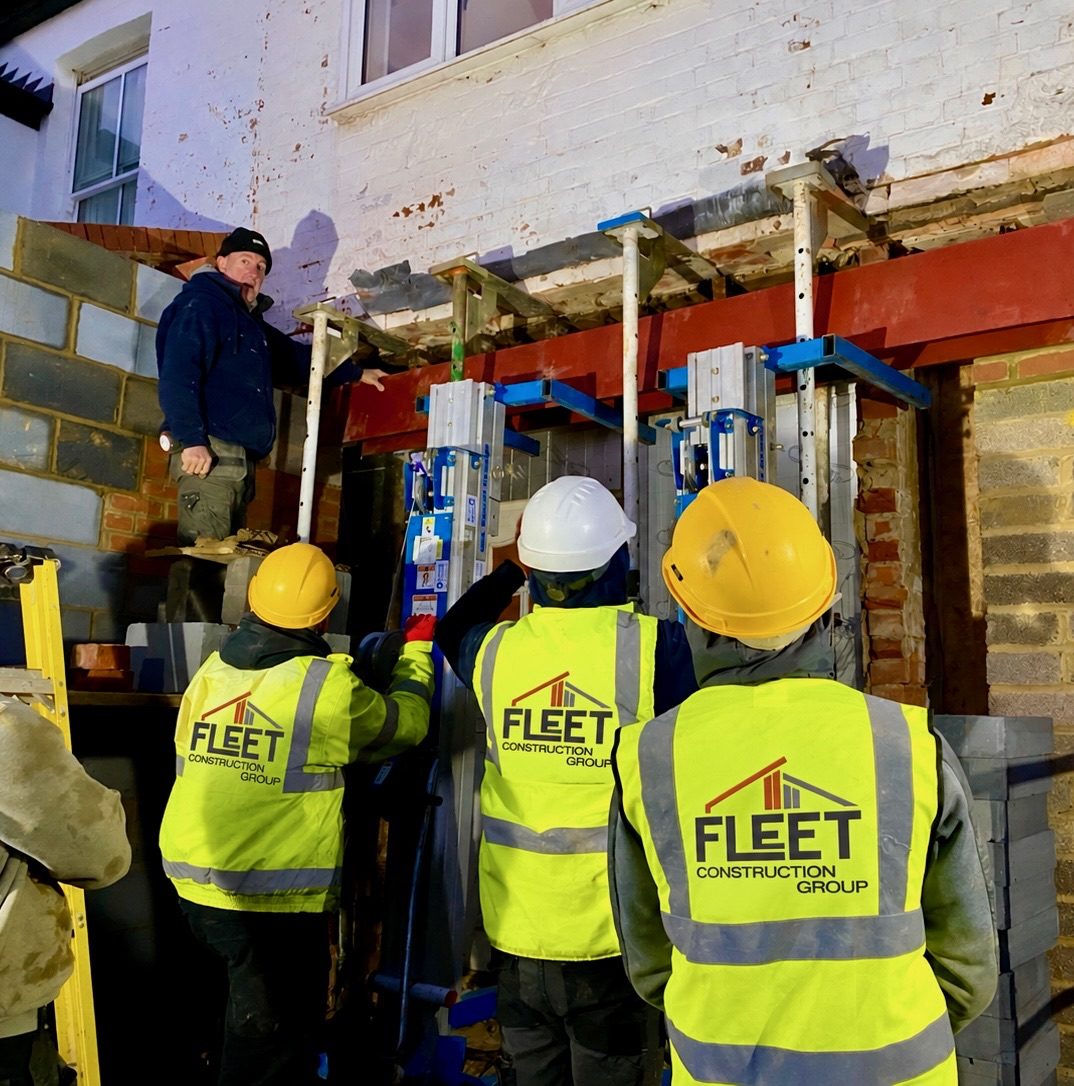 Team installing acrow props before a structural opening is formed