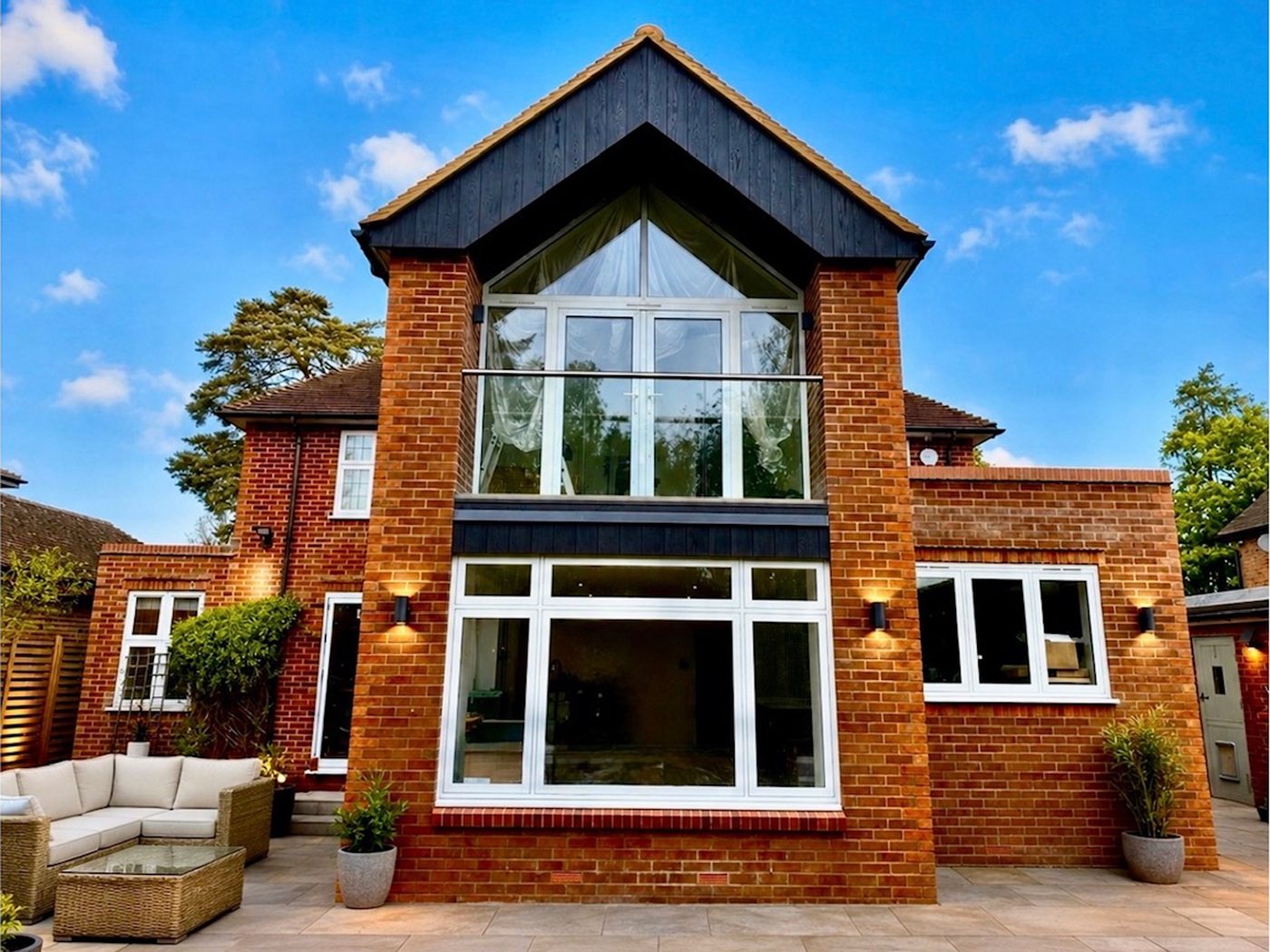 The same home after renovation, with a new gable, glazing and terrace