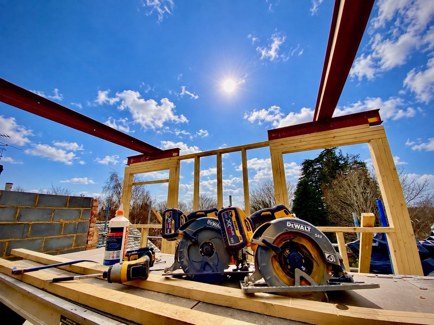 Oak and steel frame taking shape against a clear sky